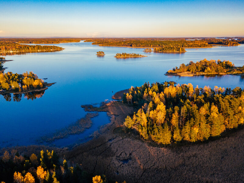 Aerial view over autumnal coastal area near Helsinki, Finland during golden hour